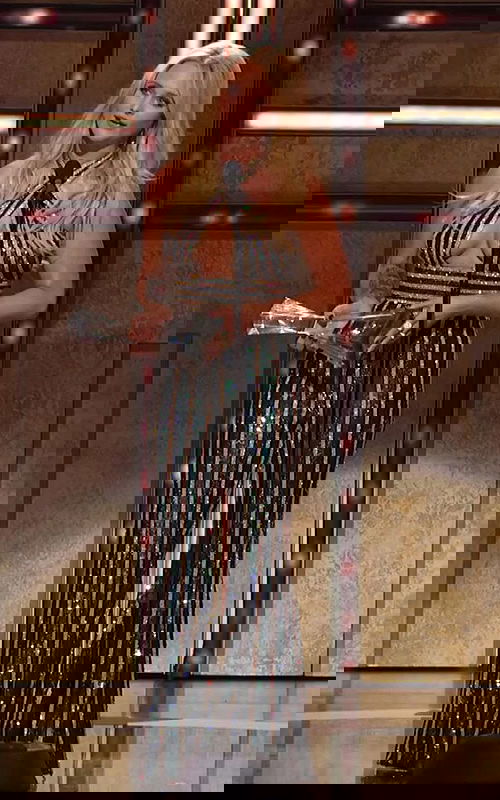 Model wearing Jovani 62493 with front view, black and gold sequin gown.