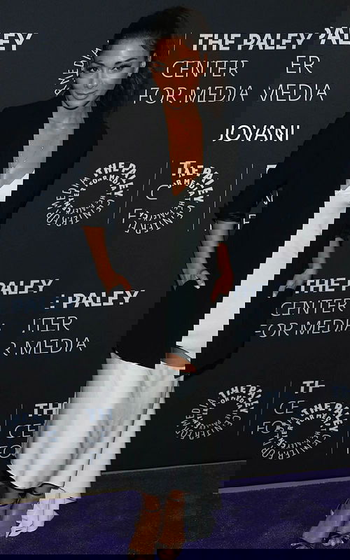 model wearing M392 elegant black dress with fitted silhouette and black blazer