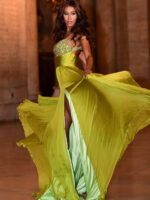 Model showcasing side view of Jovani S05823 in green with flowing skirt