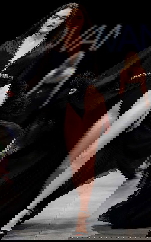 Model wearing S39276 black gown with plunging V-neckline and high slit.