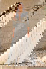 Front view of a long sleeve bridal gown with deep V neckline, flowing skirt, and crystal embellished waist.