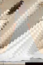 Back view of a long sleeve A-line wedding gown with beaded belt and crystal cuff details.