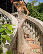 Model wearing Jovani S67085 nude gown with a plunging V-neckline and detailed embellishments.