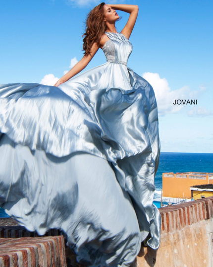 Model wearing Jovani S68289 silver gown with a halter neckline and embellished bodice.