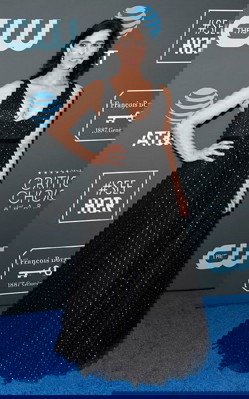 Model wearing Jovani 57696 black dress with a plunging neckline and full skirt at a formal event.