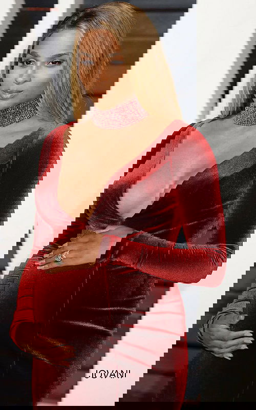 Close-up of model in Jovani S55169 burgundy velvet gown with deep V-neckline.