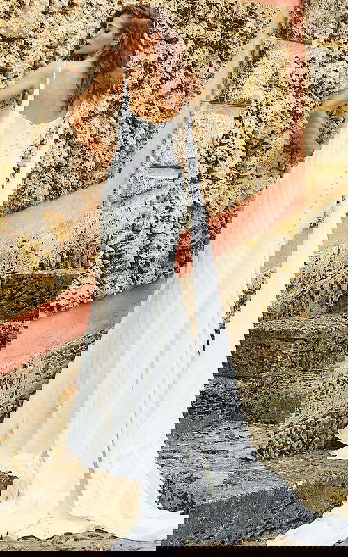 Model showcasing the back of Jovani JB07139 white gown with button detail and train.