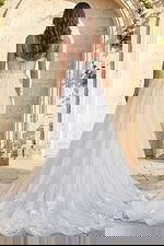 Back view of floral appliqué tulle bridal gown with thin straps and long flowing train