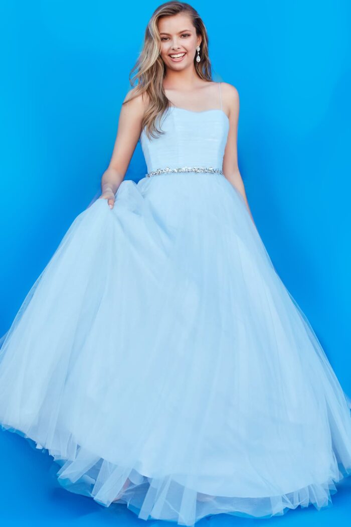 Young model in Jovani K66712 blue ball gown showcasing elegant style.