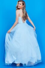 Young model in Jovani K66712 blue gown back view reflecting delicate beauty.