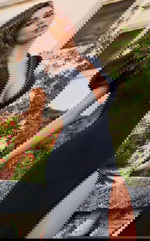 Model showcasing Jovani s04601 black dress with puff sleeves and high slit from an alternate angle.