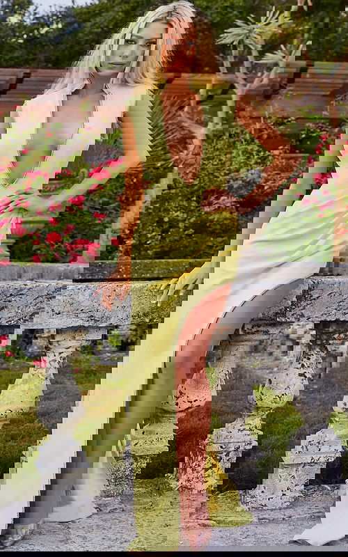 Model wearing Jovani s04667 yellow dress with deep V-neck and high slit, front view.