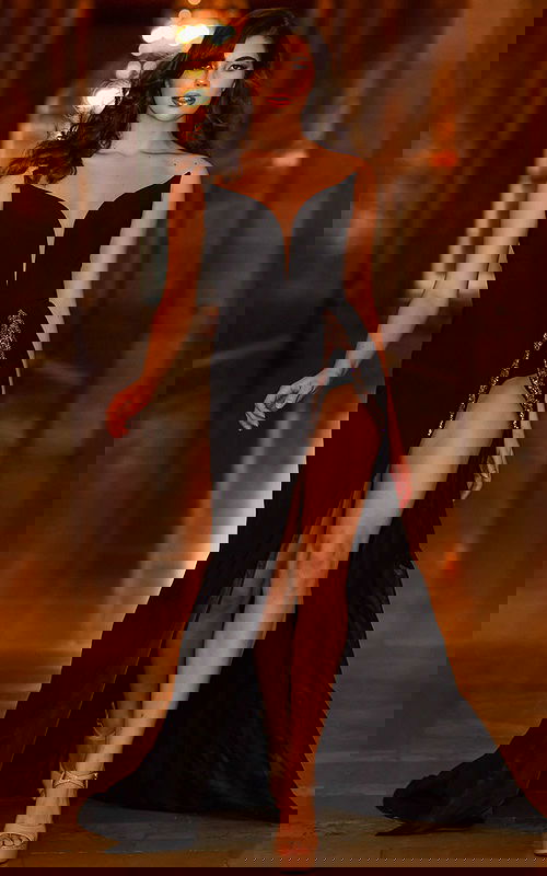 Model wearing Jovani S05934 black gown with sweetheart neckline and high slit.