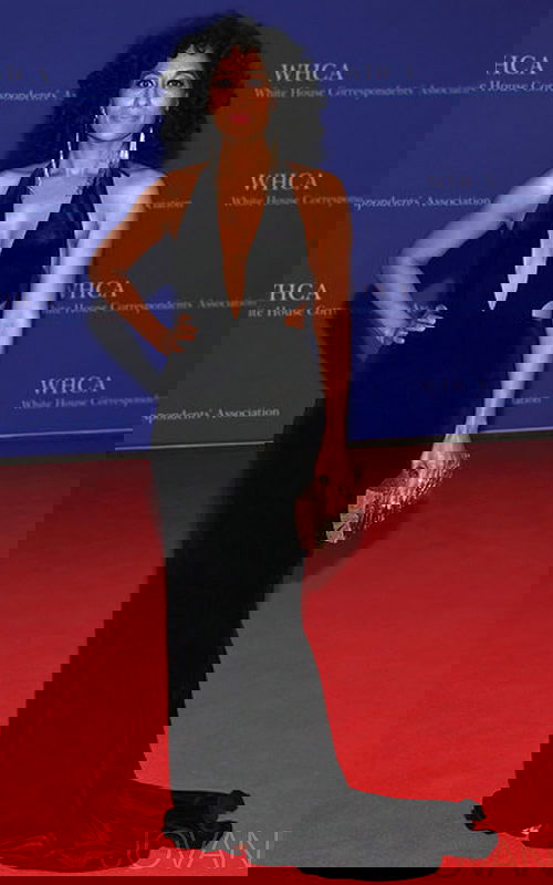 Model wearing Jovani 40454 black gown with a halter neckline and side cut-outs.